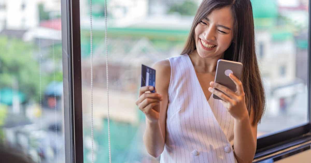 Woman smiles as she shops online at Gilt.