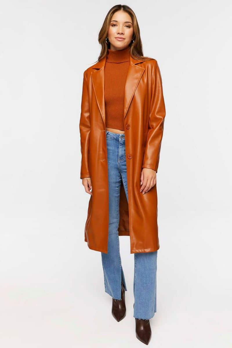 Leather Clothes are Trending: Here's How to Wear Them 7 Model wears orange leather trench coat over jeans and t-shirt.