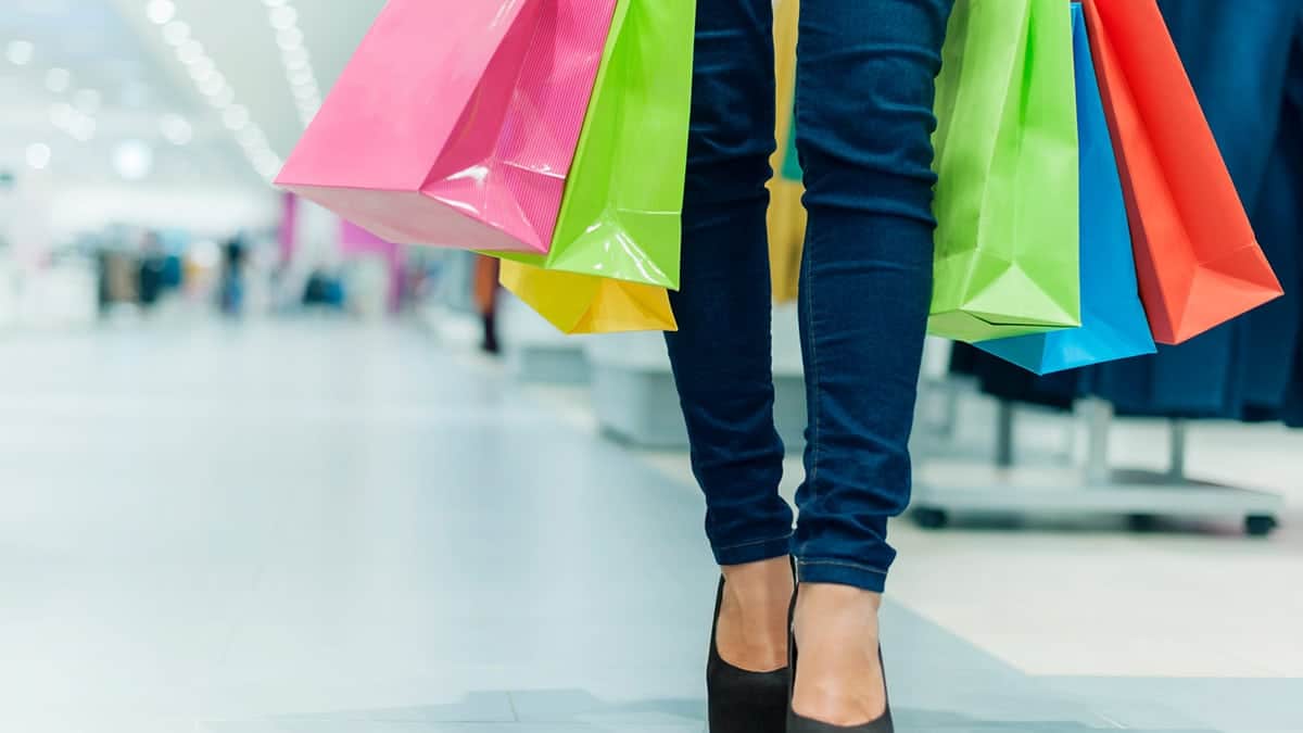 Get the Buzz of Retail Therapy Without Overspending 15 Woman with shopping bags, practicing retail therapy.