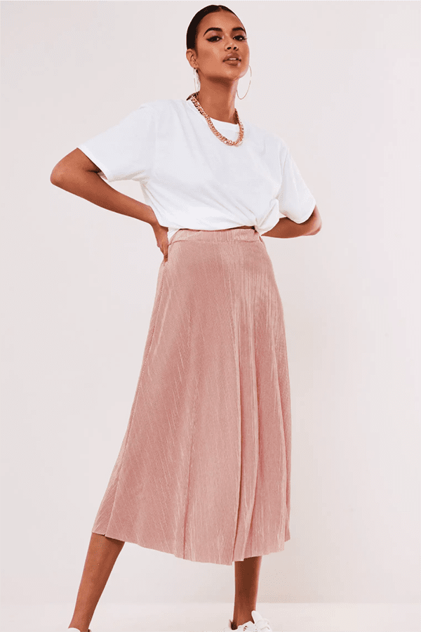 A-Line Skirt: The Silhouette That Always Flatters 27 Woman wearing pink A-line midi skirt.