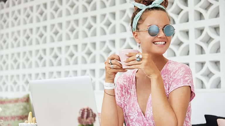 Woman wearing key fashion basics -- sunglasses, jewelry, and scarf.
