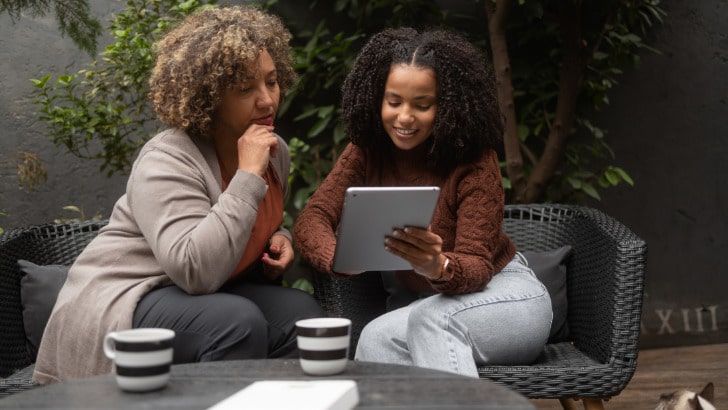 Two women shop midrange fashion online.