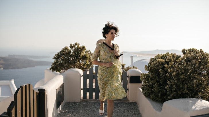 How to Style a Midi Dress 7 (Easy) Ways 98 Woman outside on deck wearing midi dress to represent how to style a midi dress.