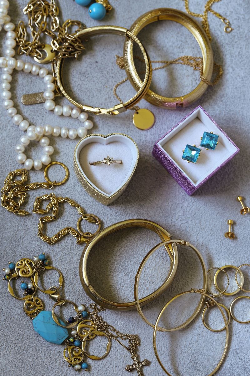 What to Buy at Thrift Stores: 5 Product Categories to Shop Secondhand 1 Collection of vintage jewelry in display at thrift store.