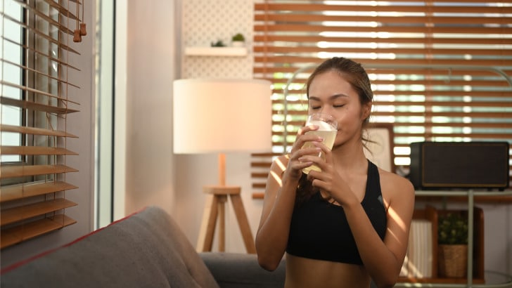 Benefits of Taking Collagen: Fact & Fiction 81 Sporty woman drinks collagen supplement.