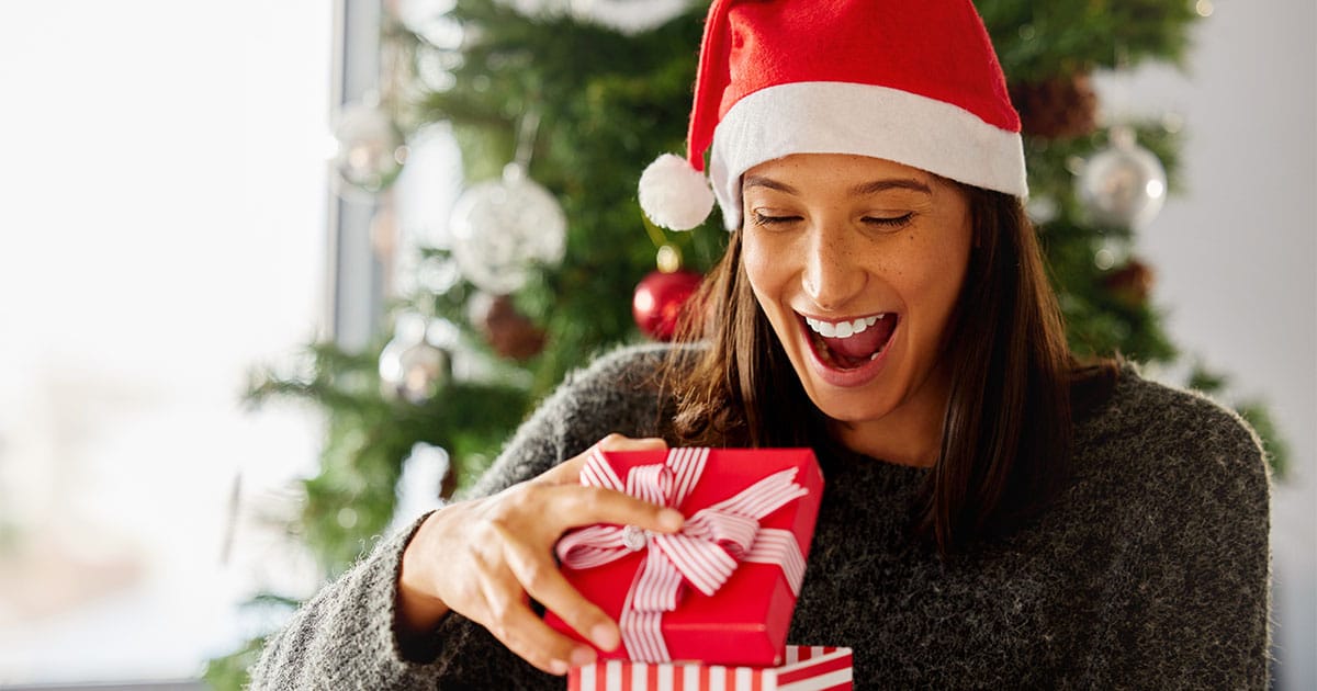 28 Clever and Thoughtful Gift Ideas for Her Under $50  66 Woman opens holiday gift.