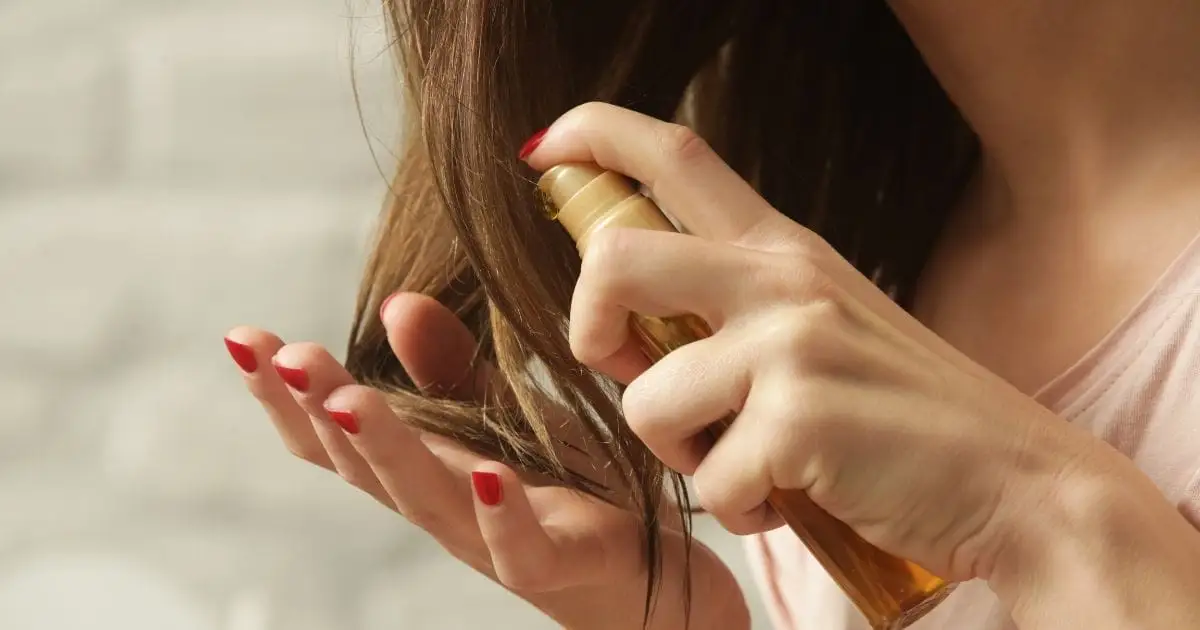 Davines: Put This Sustainable Hair Care Brand on Your Radar 49 Close-up of woman applying hair product to hair.