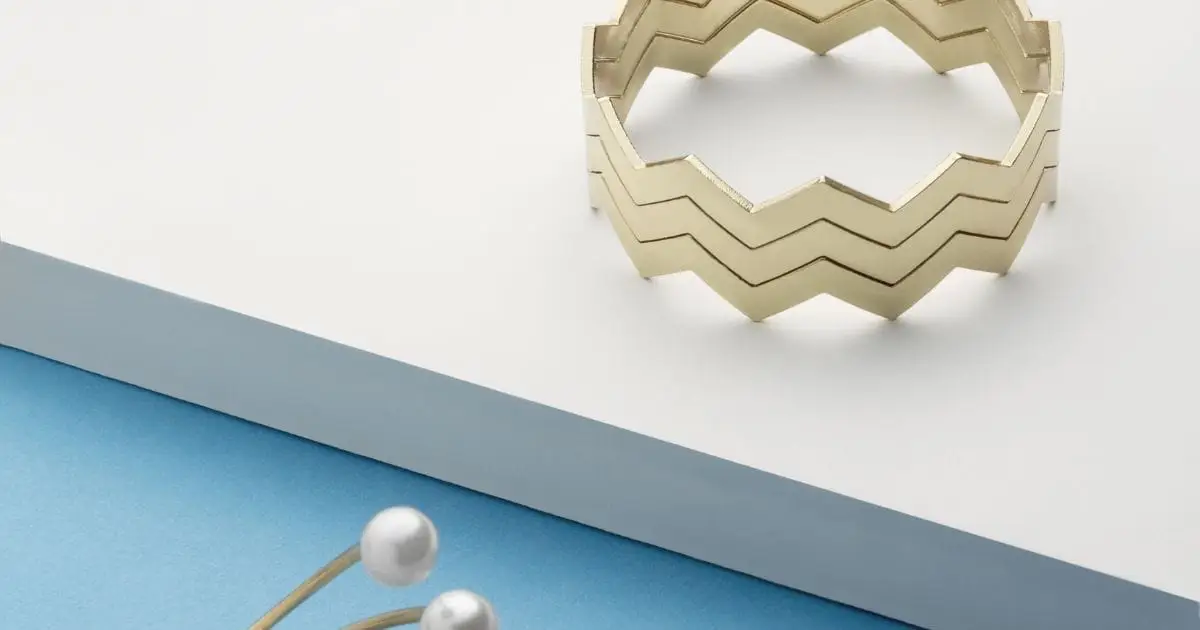 How to Score 2024's Hottest Jewelry Trends on a Budget 48 Geometric cuff bracelet and pearl jewelry piece on table.