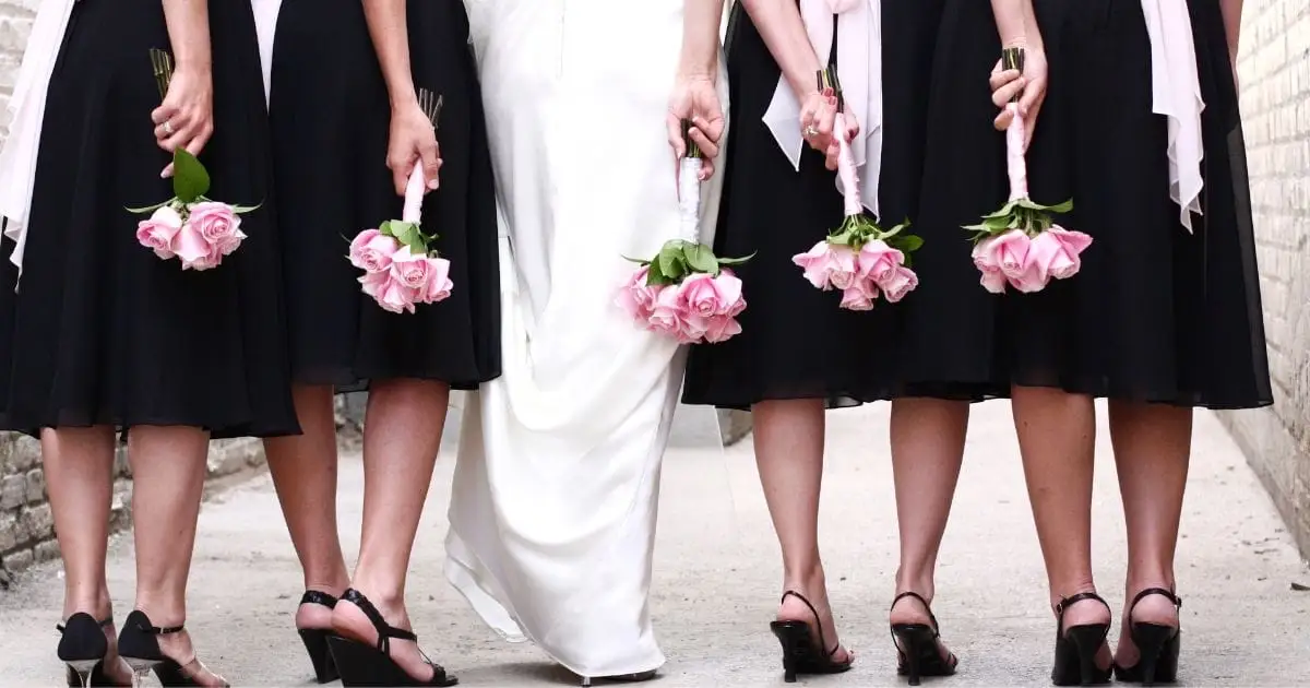 Top 7 Bridesmaid Dress Trends of 2024 44 View from behind of bridal party wearing black dresses and bride.