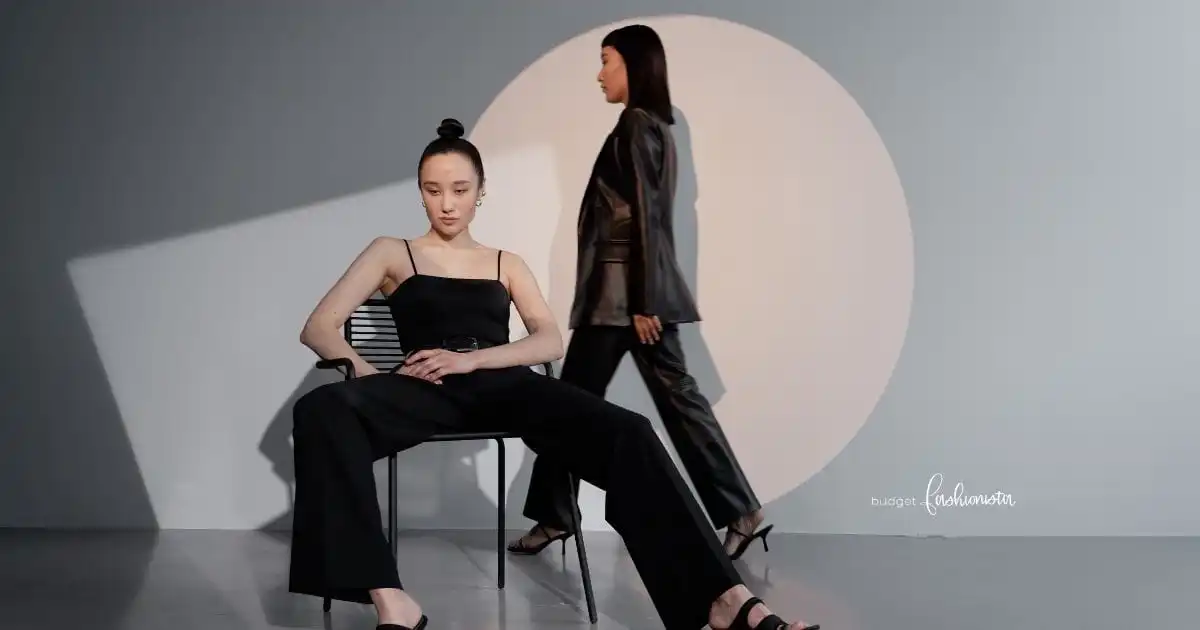 Mastering Monochrome: Styling All-Black Outfits on a Budget 29 Two woman wearing all-black outfits against geometric background.