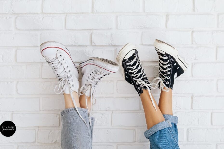 Legs in jeans wearing black and white sneakers.