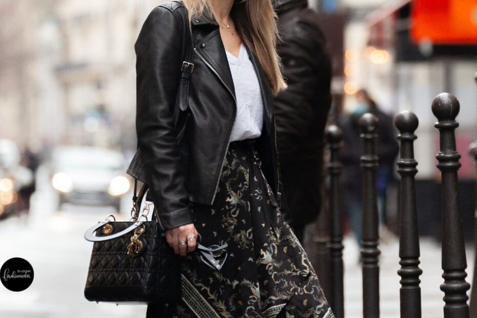 Black leather jacket, white shirt, patterned skirt.
